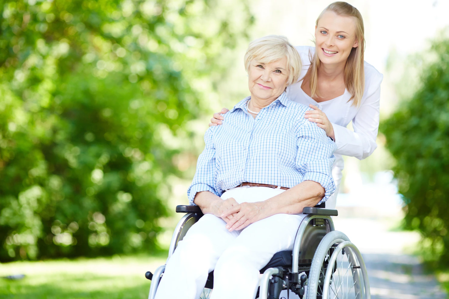 caregiver pushing senior woman wheelchair 1098 3013 1